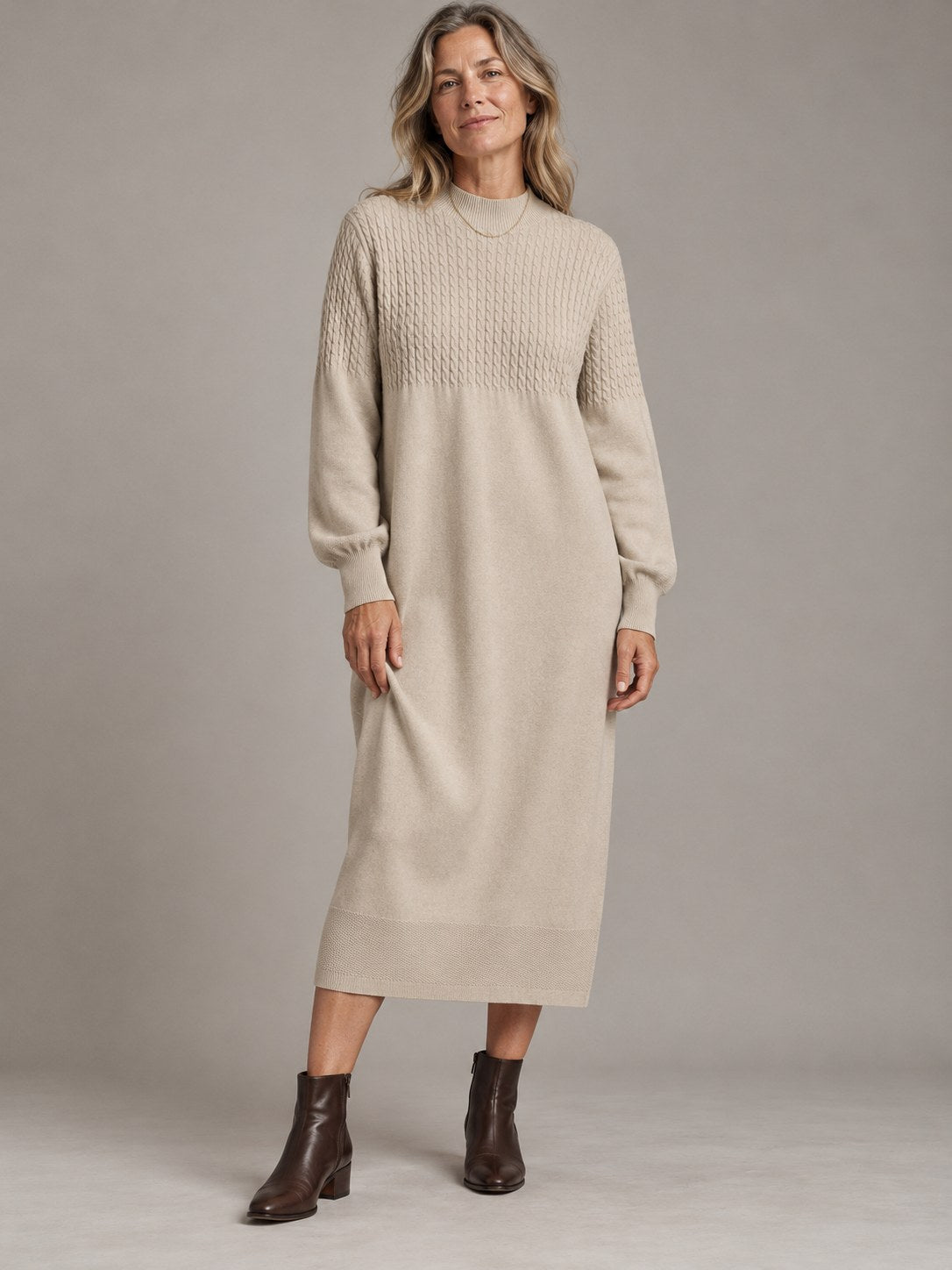 Femke beige gebreide midi truijurk met kabelpas, gedragen door model