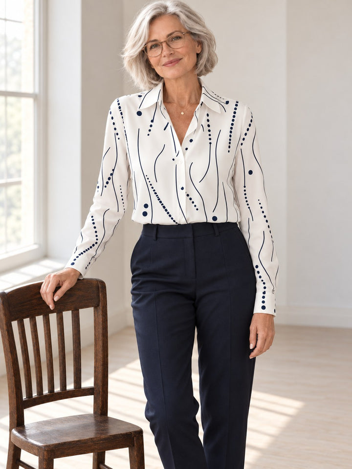 Naomi witte blouse met marineblauwe lijnen- en stippenprint, gedragen door model