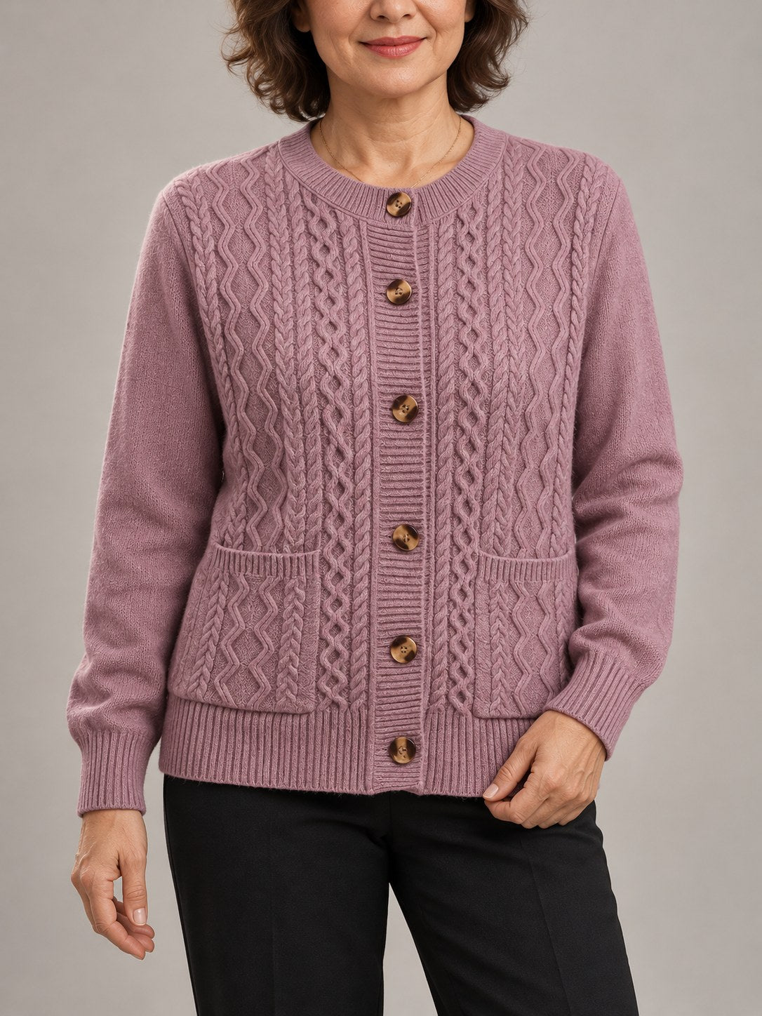 Sophie oudroze kabelvest met ronde hals, knopen en zakken, gedragen door model